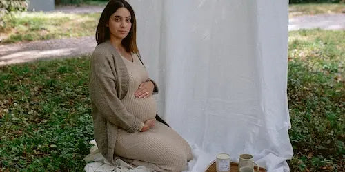 femme enceinte assise dans l'herbe