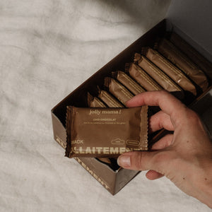 boite de cho chocolat ouvert avec une main prenant un carré