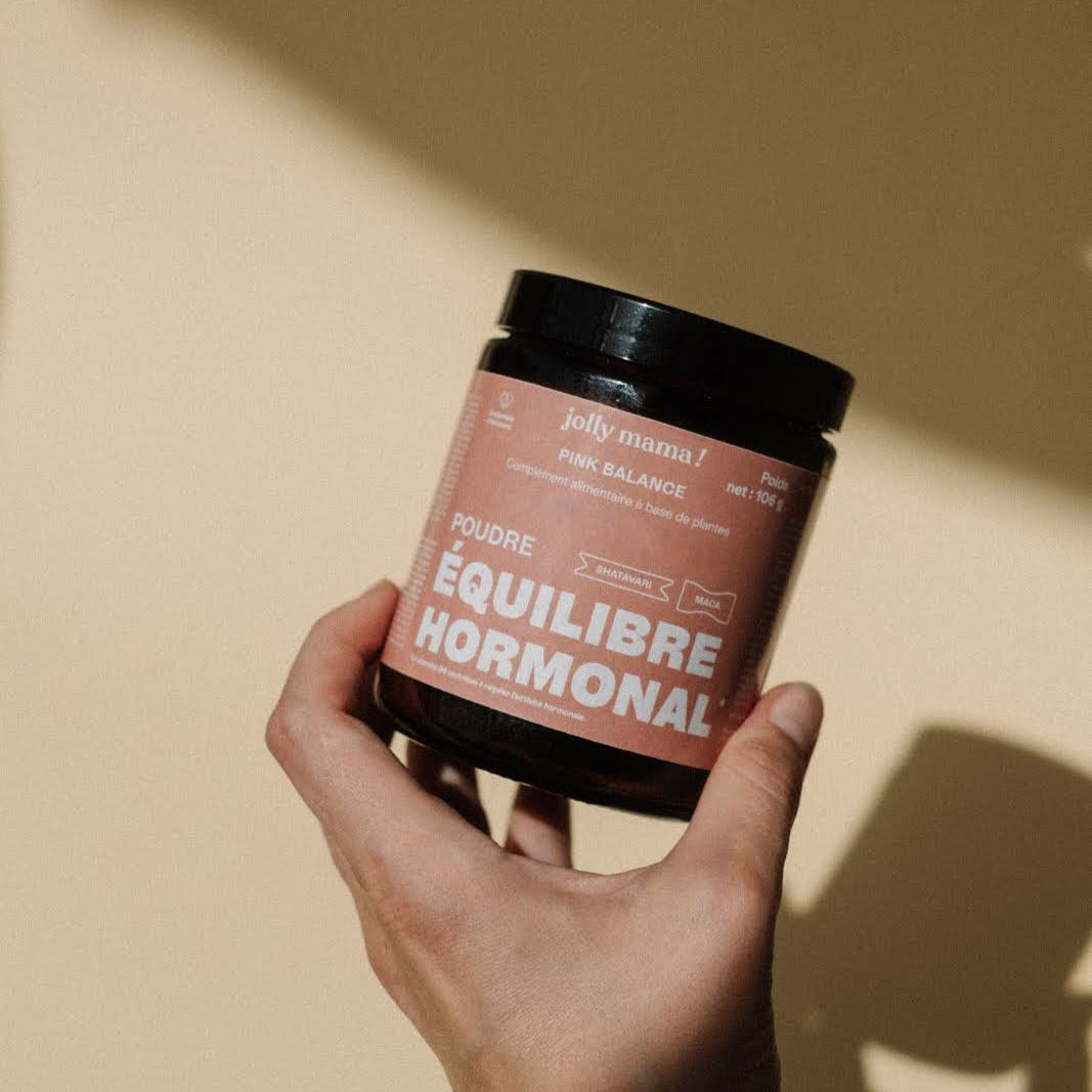 un main femme tenant  un pot de Pink balance, poudre pour l'équilibre hormonal