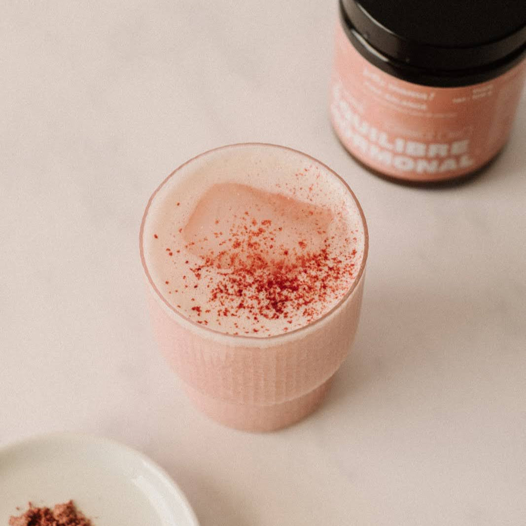 Verre contenant la poudre Pink balance, préparé avec un lait végétal