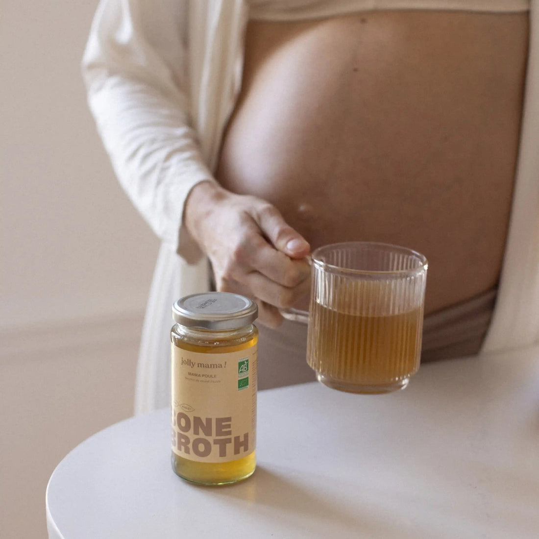 femme enceinte avec une tasse en verre et le bouillon bone broth bio Mama Poule
