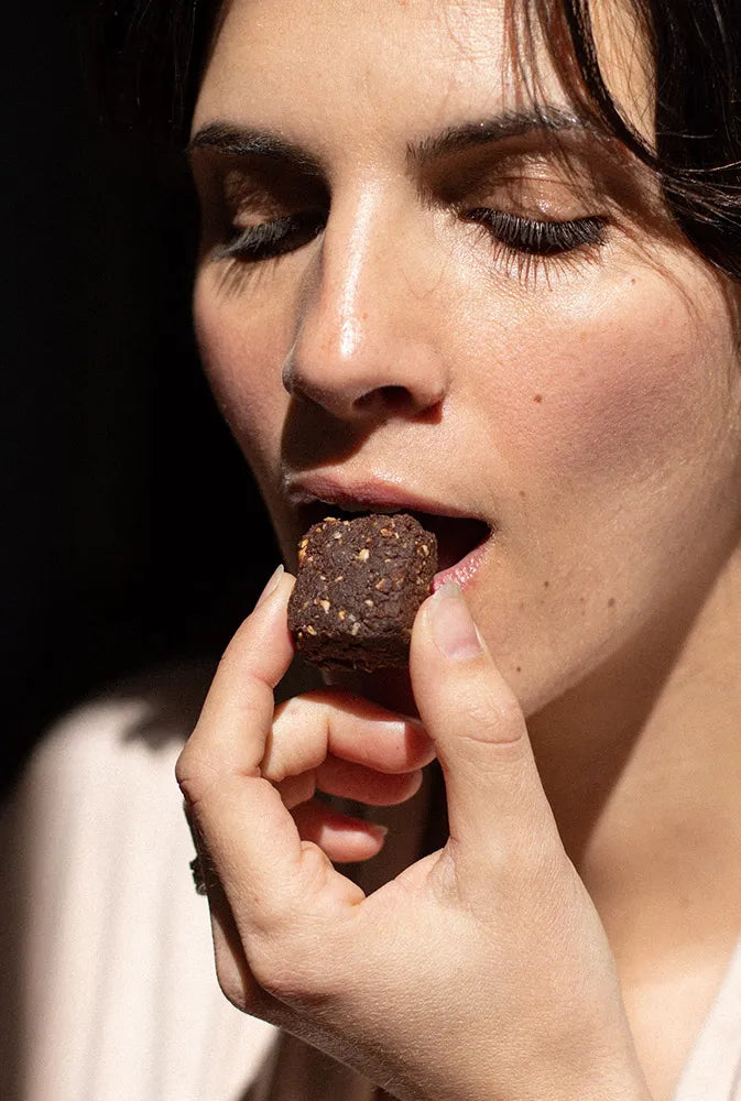 Femme savourant un encas gourmand au chocolat magnésium signé Jolly Mama – snack sain et nutritif, riche en fibres et idéal pour les petites faims pendant la grossesse ou l’allaitement.