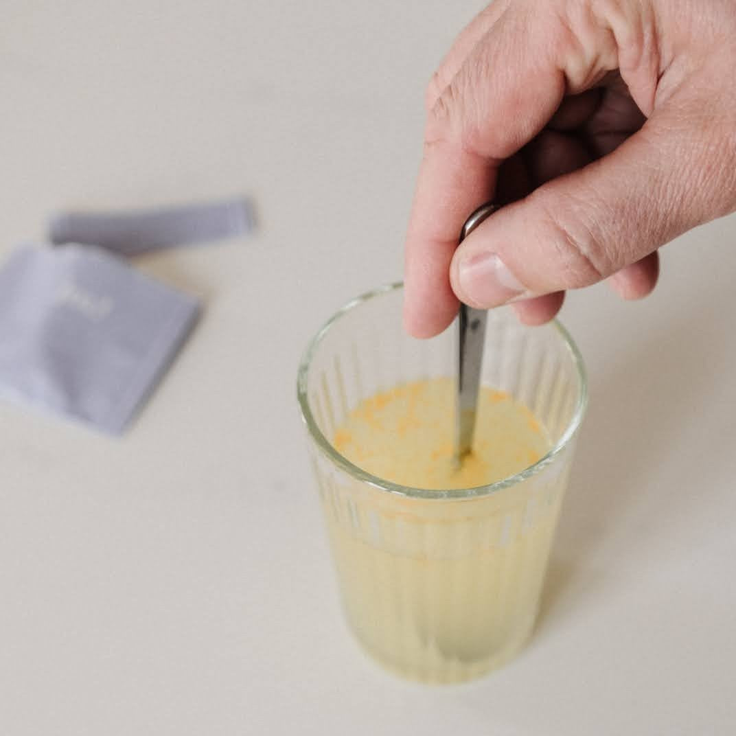 homme qui mélange son complément fertilité dans un verre d'eau