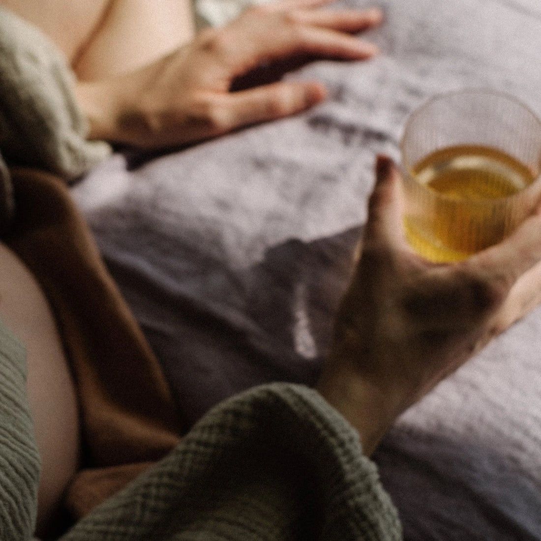Maman détendue tenant une boisson chaude à base de Mama Dreams Jolly Mama, rituel du soir apaisant
