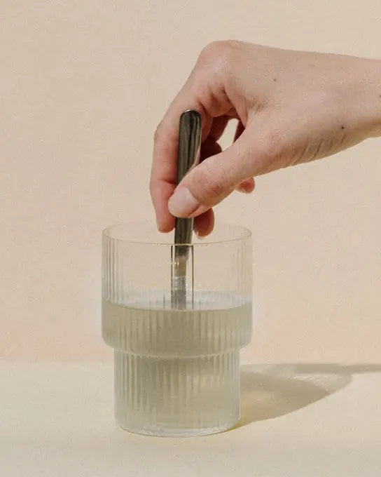 produit myo inositol poudre mélangé dans un verre