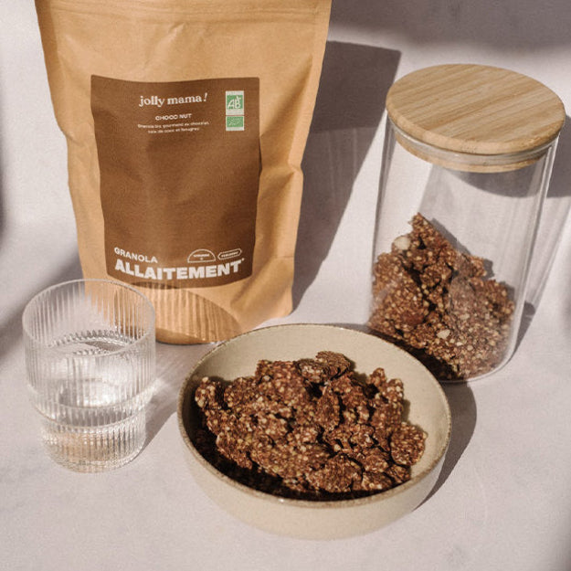 Granola allaitement chocolat servi dans un bol, avec en arrière-plan le sachet de granola d’allaitement. 